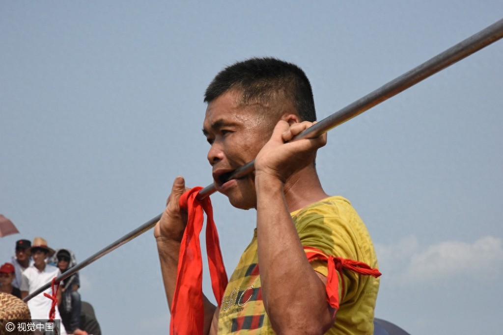 惊悚!海南定安军坡节上演“穿杖”表演,现场人山人海