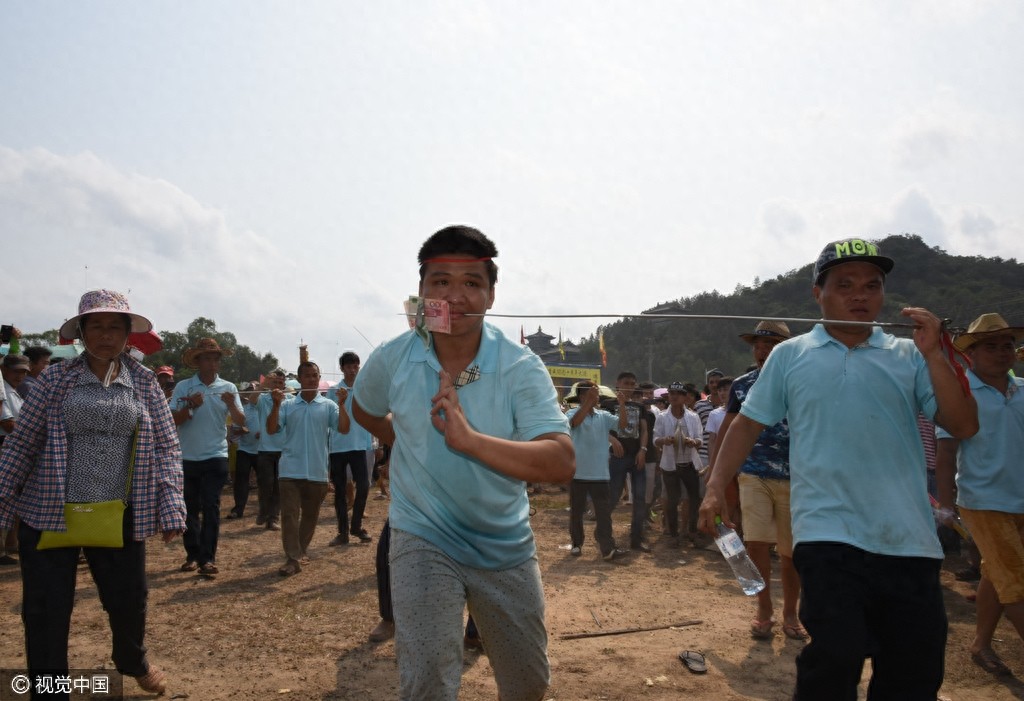 惊悚!海南定安军坡节上演“穿杖”表演,现场人山人海