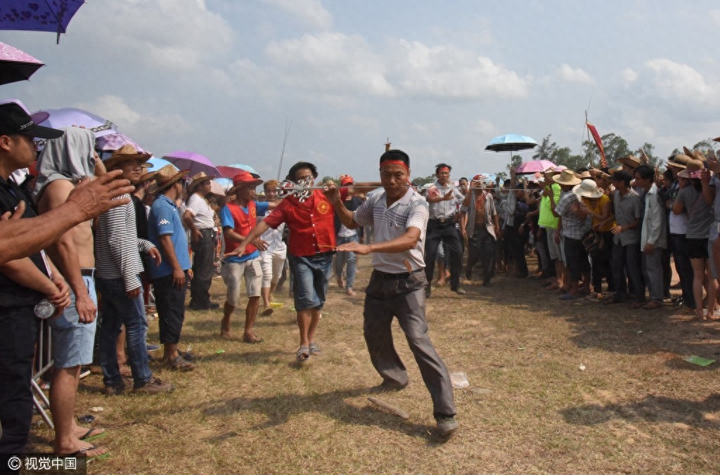 惊悚!海南定安军坡节上演“穿杖”表演,现场人山人海