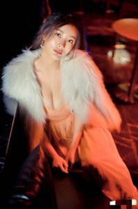 ​王李丹妮身披蓬松白狐毛披肩，一袭深V粉裙勾勒出傲人曲线